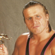 Owen Hart with his beloved Slammy Award statue in a 1996 WWE promotional image.